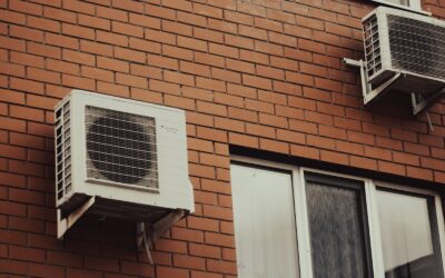 Air conditioners are attached to a brick building.